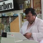 Gestore di tabaccheria che offre servizi extra per aumentare il fatturato.