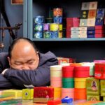 Immagine di una tabaccheria con espositori di prodotti vari, come articoli per fumatori e giochi.